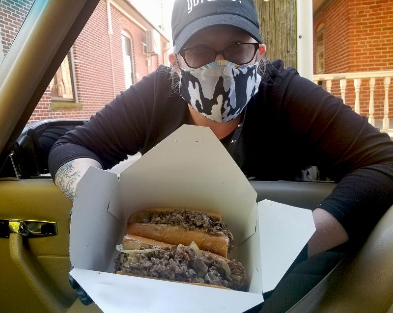 That's Milton Foxhole restaurant co-owner Kristen Latham smiling behind that mask. Like most owners and managers, she's steppin' up to the plate to provide quick curbside service for wayward food writers ... and normal customers alike. The cheesesteaks were perfect, by the way. BOB YESBEK PHOTO